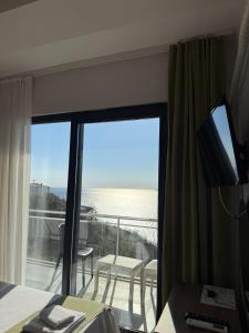 a hotel room with a balcony with a view of the ocean at Pavlonya Garden in İntepe