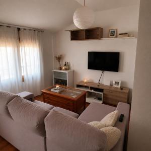 a living room with a couch and a flat screen tv at El Burgo Eclipse Retreat in El Burgo de Osma