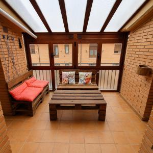 a screened in porch with a bench and two chairs at El Burgo Eclipse Retreat in El Burgo de Osma