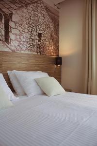 a bedroom with a large bed with white pillows at Hotel Luna in Međugorje