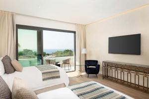 a hotel room with a bed and a flat screen tv at Parklane, a Luxury Collection Resort & Spa, Limassol in Limassol