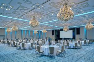 a banquet hall with white tables and chairs and chandeliers at Parklane, a Luxury Collection Resort & Spa, Limassol in Limassol +188 photos