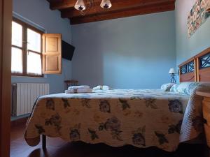 a bedroom with a bed with a bedspread with butterflies on it at Casa Rural Juaco in Bimenes