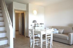 a living room with a white table and a couch at Sa Tirìa in Chia