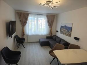 a living room with a couch and a table and chairs at Apartament Fodor in Topliţa