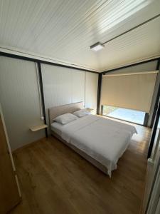 a bedroom with a bed and a large window at The Nest in Mitrovići