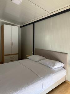 a bedroom with a white bed and a cabinet at The Nest in Mitrovići