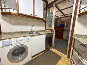a kitchen with a washing machine and a sink at Apartamento en A Coruña in A Coruña