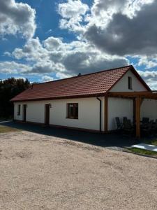 a large white building with a red roof at Domek Wśród Pisarzy in Strawczynek