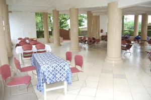 a dining room with a table and chairs in a building at Link Hotel in Lokossa