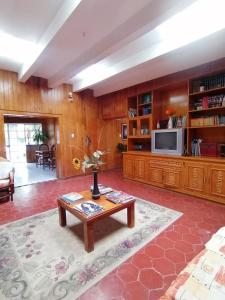 a living room with a table and a tv at Hotel Elohim Tequis in Tequisquiapan