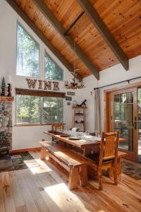 a dining room with a large wooden table and windows at Cozy Cabin - Hot Tub, Fire Pit, & Pets in Arnold