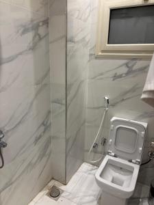 a bathroom with a toilet and a shower at Dera October city in 6th Of October +12 photos