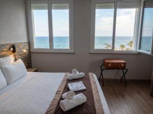a bedroom with a bed with a view of the ocean at Logis Mar I Sol - Hôtel Restaurant en bord de Mer in Saint-Cyprien