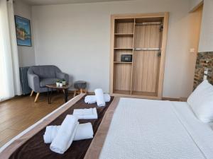 a living room with a bed and a chair at Logis Mar I Sol - Hôtel Restaurant en bord de Mer in Saint-Cyprien