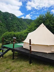 a large white tent on a table with a green table at Camping Inima Retezatului in Nucşoara