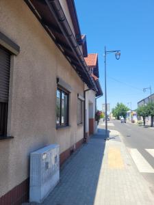 a building with a bench on the side of a street at Termalne Pokoje in Uniejow +2 photos