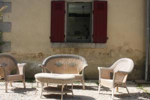 three wicker chairs sitting in front of a building at Demeure Les ragottières in Le Plessis