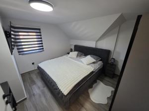 a bedroom with a bed and a window at UP & DOWN Holiday House in Donji Prozor