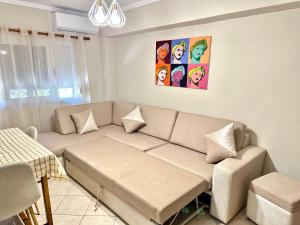 a living room with a couch and a painting on the wall at Luna Apartment in Durrës