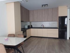 a kitchen with a white table and a black refrigerator at AMA Home in Sebeş