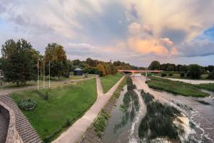 a bridge over a river next to a river at Viešbutis Banga in Tauragė
