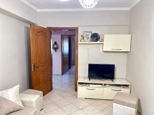 a living room with a tv and a couch at Luna Apartment in Durrës