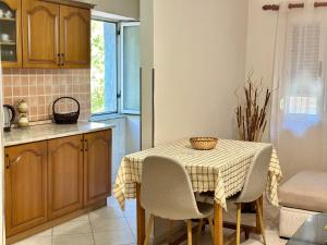 a kitchen with a table and chairs in a kitchen at Luna Apartment in Durrës