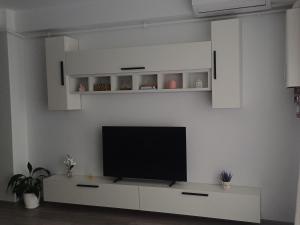 a living room with a tv on a white wall at AMA Home in Sebeş +1 photo