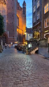 a cobblestone street in front of a large building at Baltic Gdańsk OLD TOWN in Gdańsk