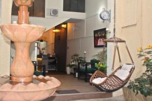 a living room with two hanging hammocks and a kitchen at Hotel Boutique La Casona in Tarija