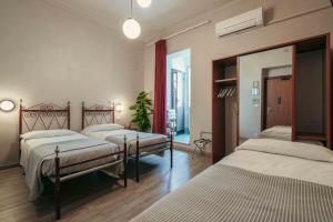 a bedroom with three beds and a mirror at Hotel Italia in Turin