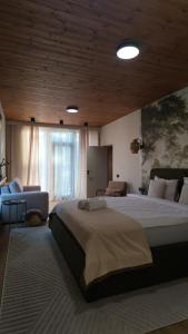 a large bedroom with a large bed and a couch at ArcChalet Transylvania in Borzont
