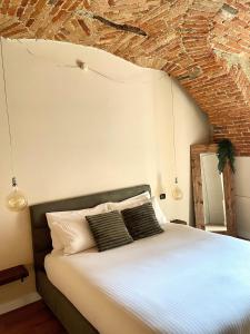 a bedroom with a bed with a brick wall at La Morra Relax in La Morra