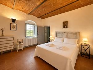 a bedroom with a white bed and a wooden ceiling at Podere di Montecchio in Florence +97 photos