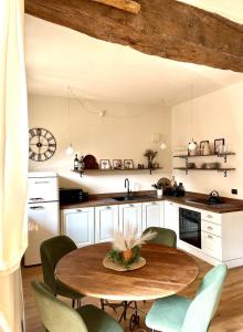 a kitchen with a wooden table and green chairs at La Morra Relax in La Morra