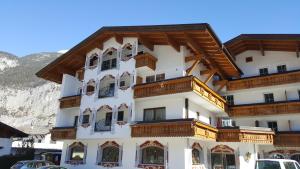 a large white building with wooden balconies at Alpenhotel Gurgltalblick in Nassereith