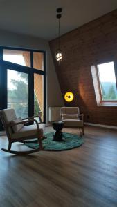 a living room with two chairs and a table at ArcChalet Transylvania in Borzont
