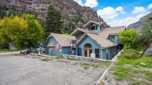 a blue house in front of a mountain at Black Bear Manor in Ouray