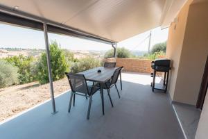 a table and chairs on a balcony with a view at Halanus Agriexperience in Alanno