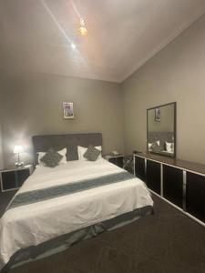 a bedroom with a large bed and a mirror at شقق نزل النخيل in Riyadh