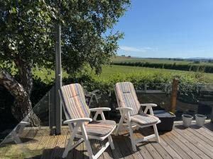 two chairs sitting on top of a wooden deck at 36 Ravens Nest large 3 bedroom lodge with views No sign written vans allowed on site in High Hesket