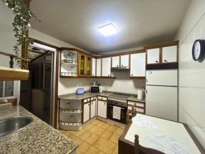 a kitchen with wooden cabinets and a white refrigerator at Apartamento en A Coruña in A Coruña