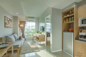 a kitchen and living room with a couch and a table at Thongchen Residence in Samut Sakhon