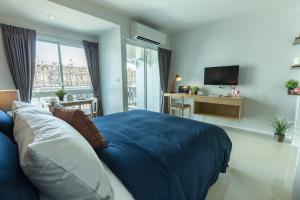 a bedroom with a blue bed and a television at Thongchen Residence in Samut Sakhon