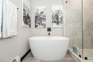 a white bathroom with a large white tub in it at NEW Ski-In Ski-Out Romantic Studio for Two in Winter Park