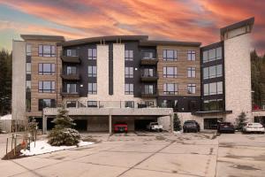 a large building with cars parked in a parking lot at NEW Ski-In Ski-Out Romantic Studio for Two in Winter Park +24 photos