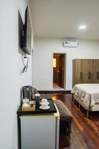 a room with a bed and a table with a television at Hotel Boutique La Casona in Tarija
