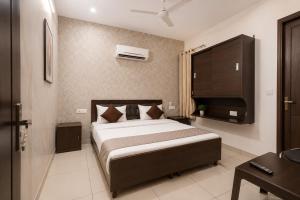 a bedroom with a large bed and a television at Hotel Devine Opp Jubilee Walk Mall & Near Gurdwara Sohana in Sohāna