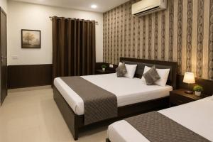 a hotel room with two beds in a room at Hotel Devine Opp Jubilee Walk Mall & Near Gurdwara Sohana in Sohāna